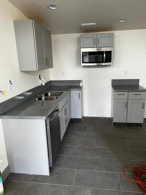 We assisted with this apartment complex install setting up grey shaker cabinets and impala black granite