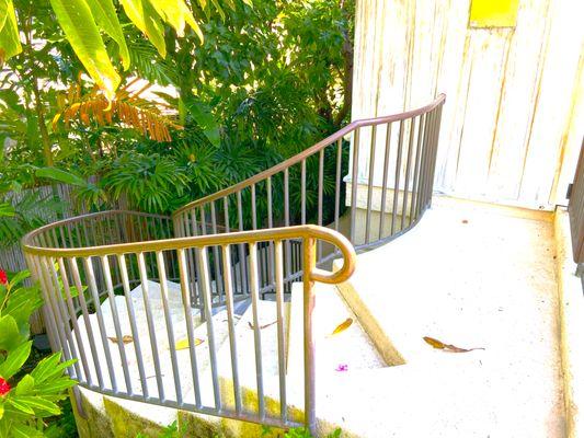 Simple bronze and brass  radius staircase leading to an amazing landscape garden.