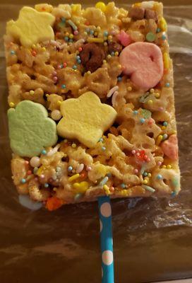 Rice Krispy treat on a stick. Has Lucky Charms, Easter decor, glitter.