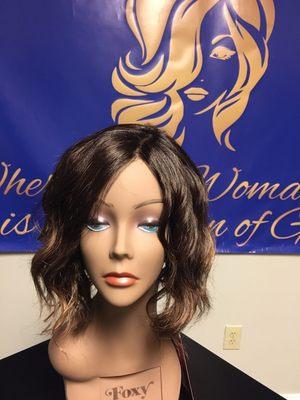 A salon finished beach wave curls that fall shoulder length in this trendy bob with a lace-front mono part cap.