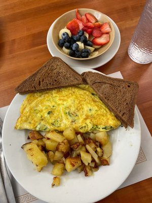 A broccoli, spinach, and American cheese omelette with home fries, rye toast, and a side of fresh fruit!