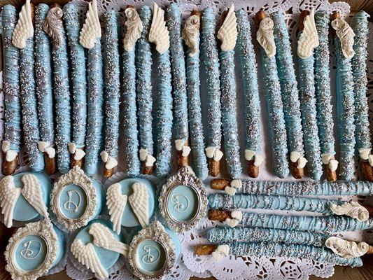 Chocolate covered pretzel rods, chocolate covered Oreos in baby blue and silver with white accents