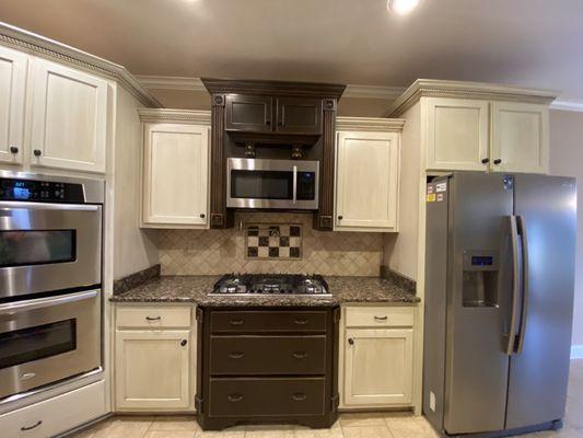 Cream with antique glaze and brown distressed framing the stove