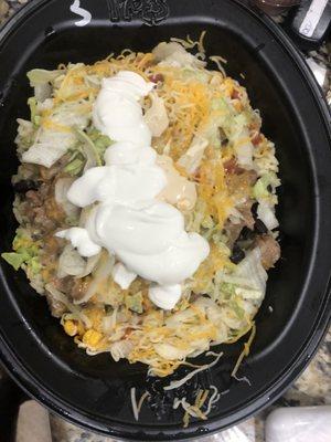 Bowl with steak, white rice, salad, cheese and sour cream