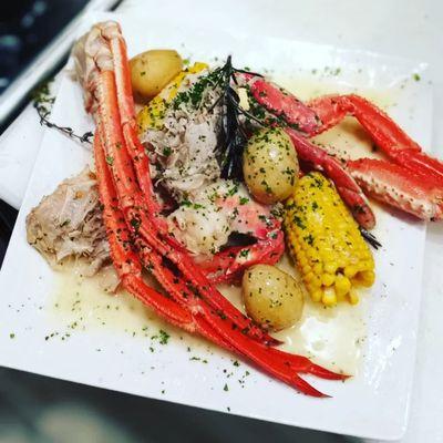 Valentine's Catering dinner consisting of King crab , dungeness crab boil with honey potatoes and corn on a bed of lemon burr Blanc.