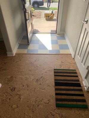 Checkered Marmoleum in entry transitioning to a floating cork panels