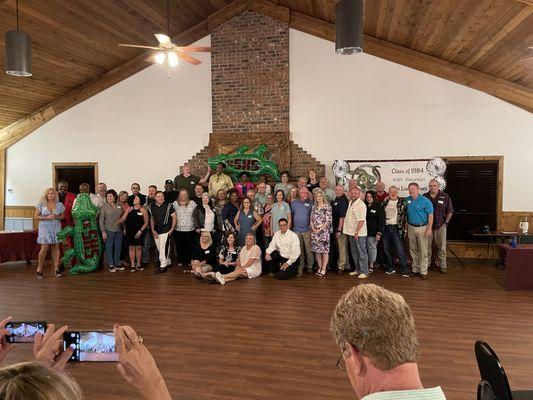 A class reunion inside the lodge in front of the fireplace