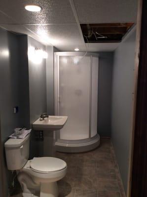 Remodeled Bathroom in basement,includes shower, toilet, sink, flooring, walls, lights, heat lamp with exhaust fan in ceiling.