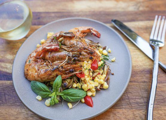 Blackened head on prawns over summer corn and basil salad.