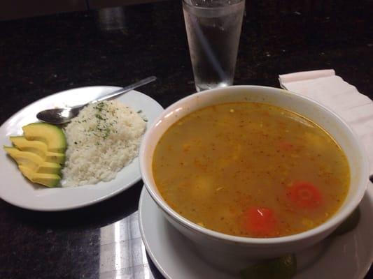 Chicken soup with side of rice and avocado