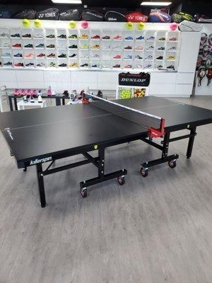 Ping pong table, with assorted shoes in the back wall