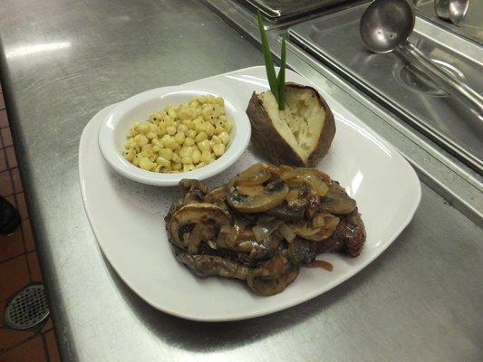 Rib eye steak dinner, topped with sauteed mushrooms and onions.