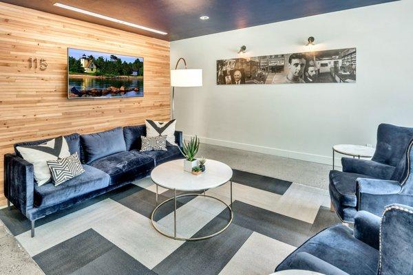 Lobby with lounge seating and wood paneled wall.