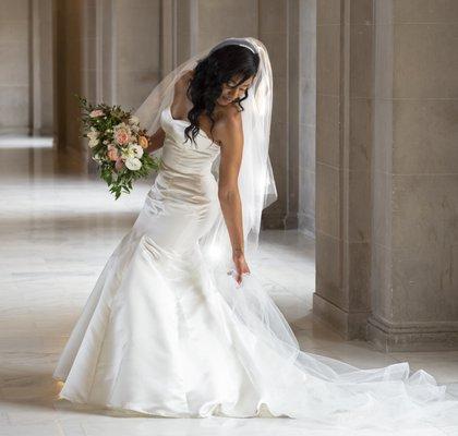 SF Hall bride beautifully reaches down to adjust her wedding dress