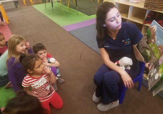 Teacher reading a story to children.