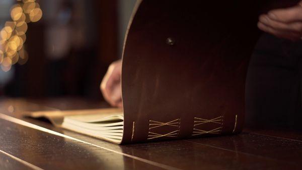 Product shot flipping through a journal (with emphasized audio to create a textural experience from the soft sounds of leather and paper)