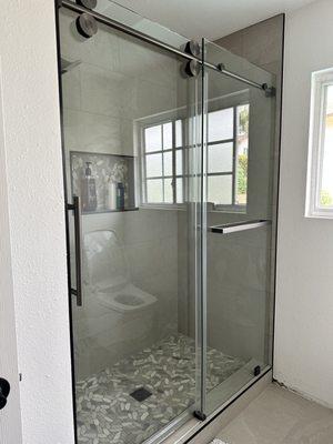 Custom Frameless sliding shower door with custom towel bar panel 
SS04 Series