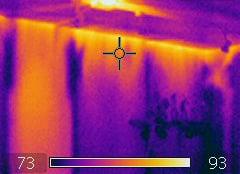 this is an infrared photo showing how hot air is leaking into an inside wall from the attic of the typical home.