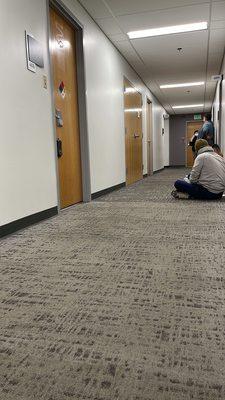 Rest of hallway full of people behind locked office door.