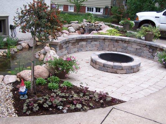 Small space solution: Patio with fire pit with waterfall and stream behind it, and plantings too!