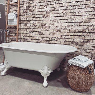 The traditional cast-iron tub goes perfect with exposed brick for a traditional classic look.