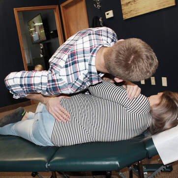 Chiropractor Mike Dumond performs a pelvic adjustment in order to address low back pain