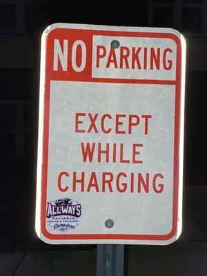 Doesn't say for electric cars.  It says, "no parking except while charging."  He never moves his Tesla.