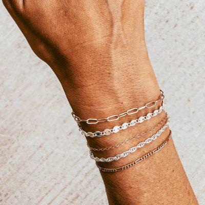 Stacked permanent bracelets.