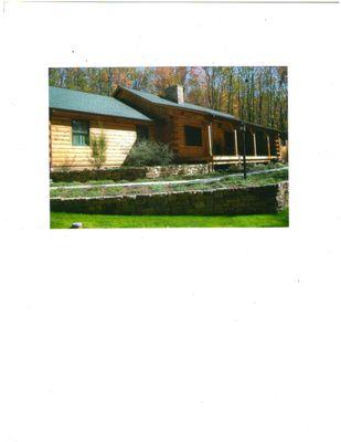 Log home with stone retaining walls