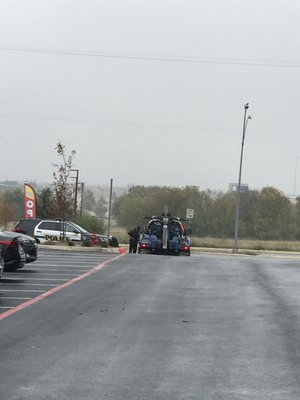 Police officer having a lengthy conversation with the Texas Tow truck driver who collected $175 from me after towing my car only 400 feet.