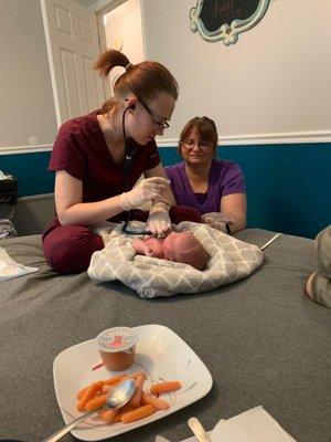 Newborn exam. You can see part of the meal they brought me after birth. I had already eaten the sandwich.