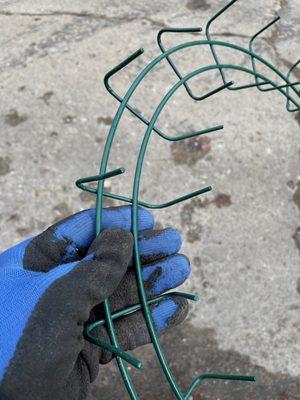 Christmas wreath greens are held in place with prongs that can be pulled apart to release greens for composting after Christmas.  No wires.