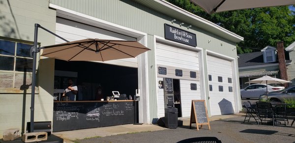 Sitting in the outdoor patio on a sunny day looking back to the bar and the brewery