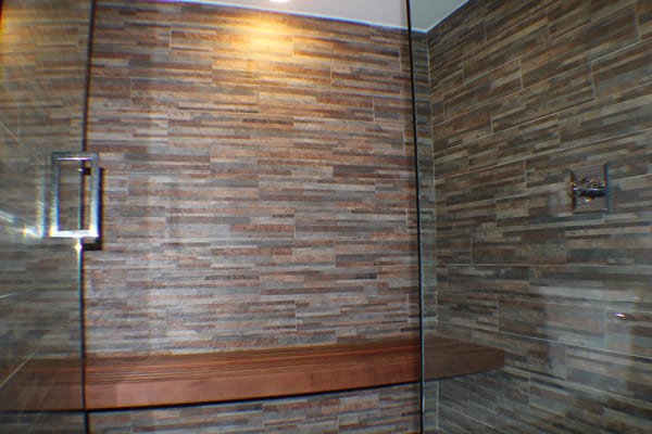 walls: ledge tile
  bench:Modern linear design.  Wood Species: Ipe  "ee-pay" Very dense and water resistant naturally.
  Frameless glass