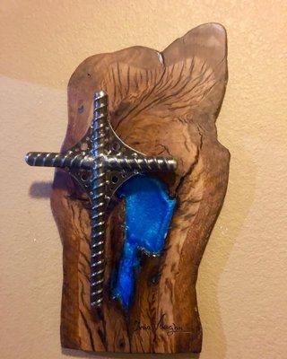 Polished rebar welded cross on aged, live edge polished oak backdrop with blue acrylic inlay.