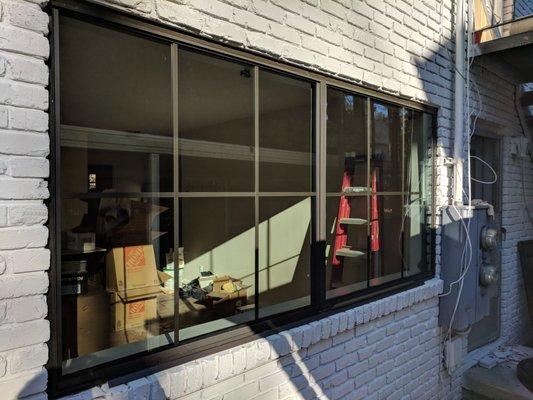 Bronze aluminum picture window with grids. Exterior.