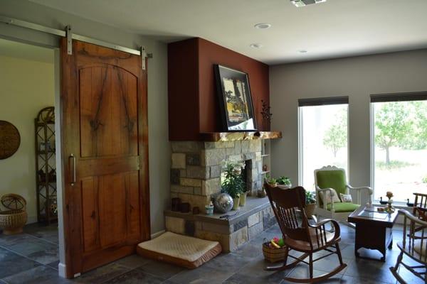 Sliding barn doors are becoming more popular everyday. Here is a mesquite door with matching mantle next to it.