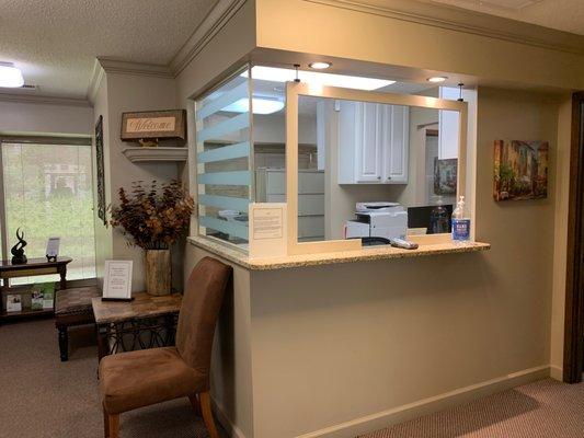 Lobby with regularly cleaned transparent shield for patient and team protection.