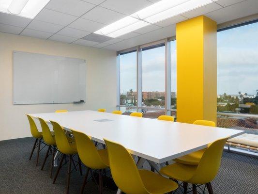 Large conference room with floor-to-ceiling glass windows & whiteboard.