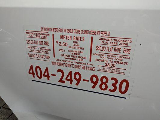 Sticker with meter rates, phone number, and other info on the outside of the Omega Taxi Co. minivan I rode in from the airport.