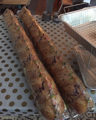 Giant sandwiches wrapped with individual toothpicks holding together the sandwiches