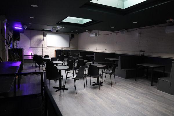 Spacious back room with stage, booths and dance floor