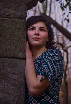 Teen girl leaning on stone wall