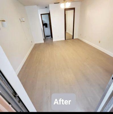 Painted bedroom with new baseboards and vinyl flooring