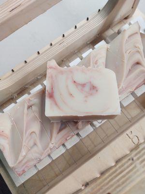 Cutting our natural soap loaves into bars before they cure for an entire month. Pictured here is our Lychee Fruit Soap.