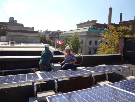 ASIDACO team members testing a commercial roof mounted solar P.V. system