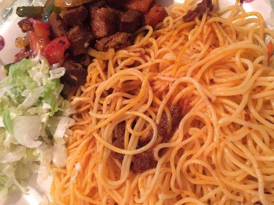 Baasto (spaghetti and tomato sauce), suqaar (beef chunks) and salad. This is a home plate as it was a to-go order