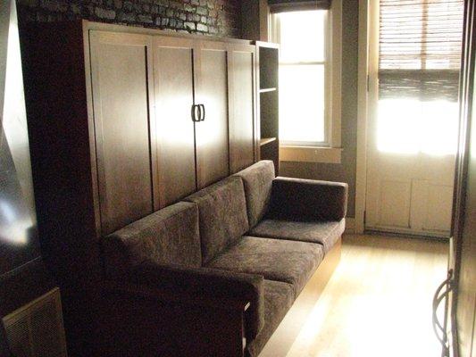 Another angle queen size distressed cherry Murphy bed with end table and book case.