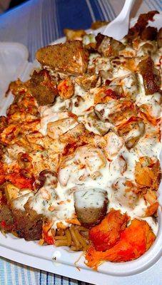 Chicken and lamb over rice with hot sauce and white sauce.