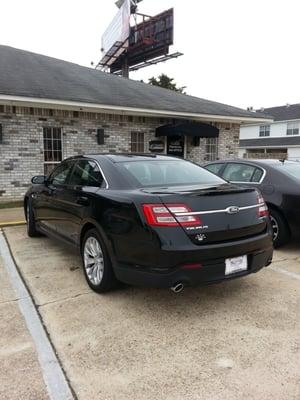 High end 4th sedans dot the parking lot.